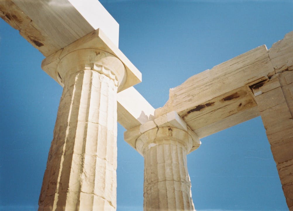 Historic columns of the Parthenon under bright sunlight in Athens, Greece.