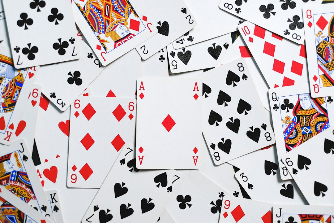 A collection of scattered playing cards showcasing various suits and numbers for casino themes.