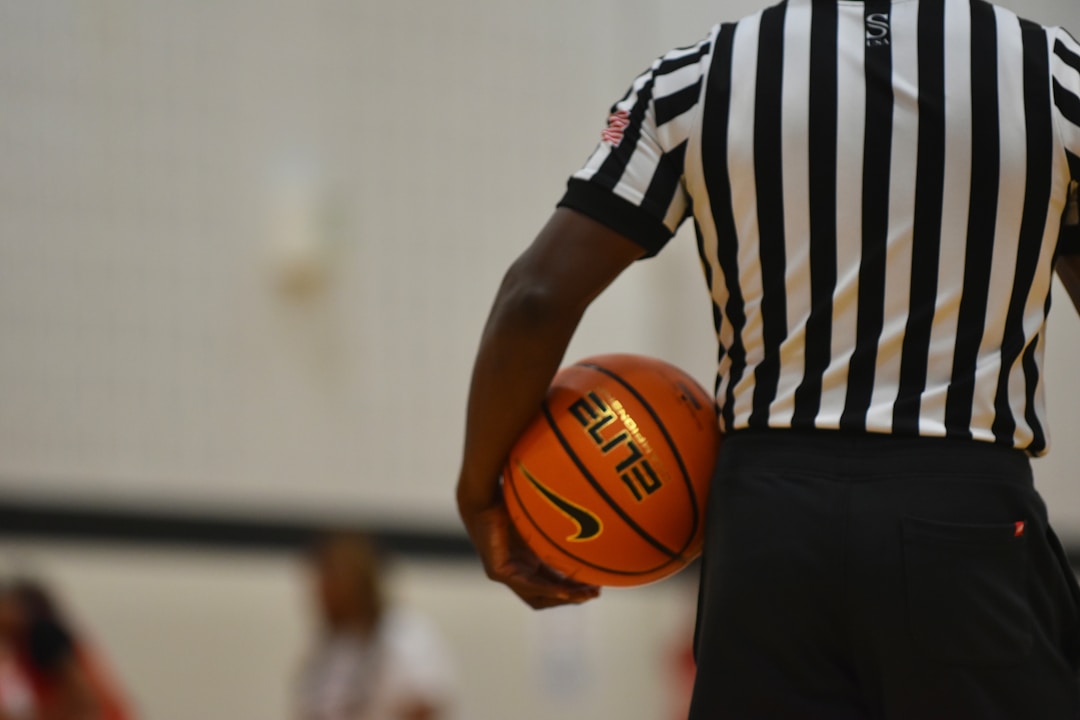 a referee holding a basketball on a court